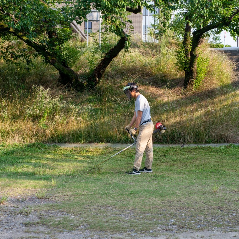 乙川で草刈りをする人