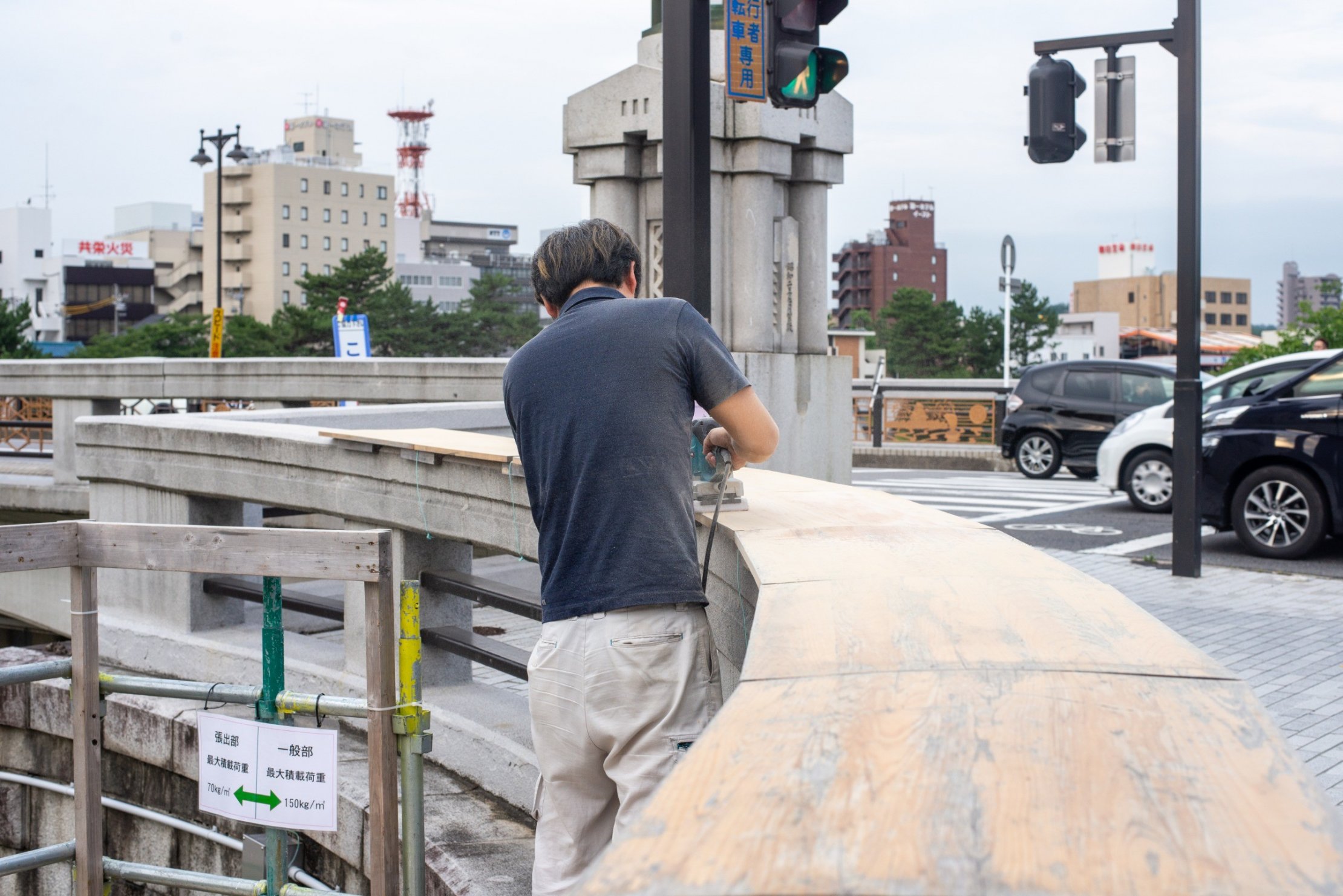 殿橋テラスのデッキにサンダーをかけているところ
