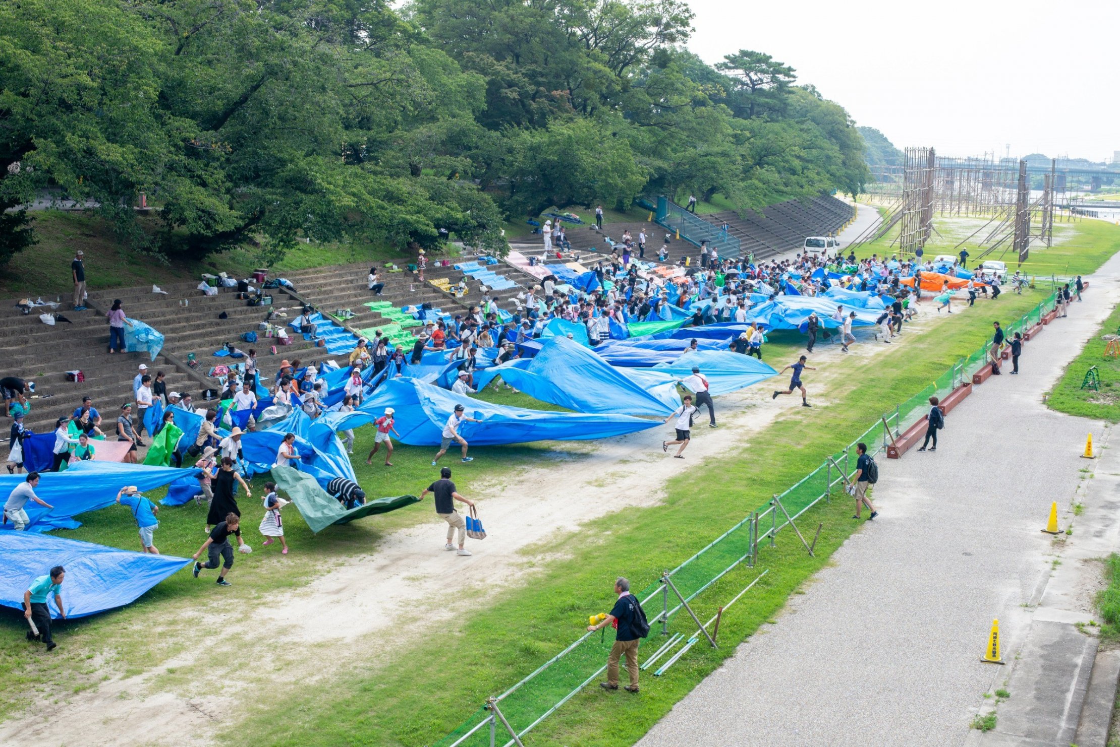 岡崎の花火大会の場所とりでブルーシートを広げる人々